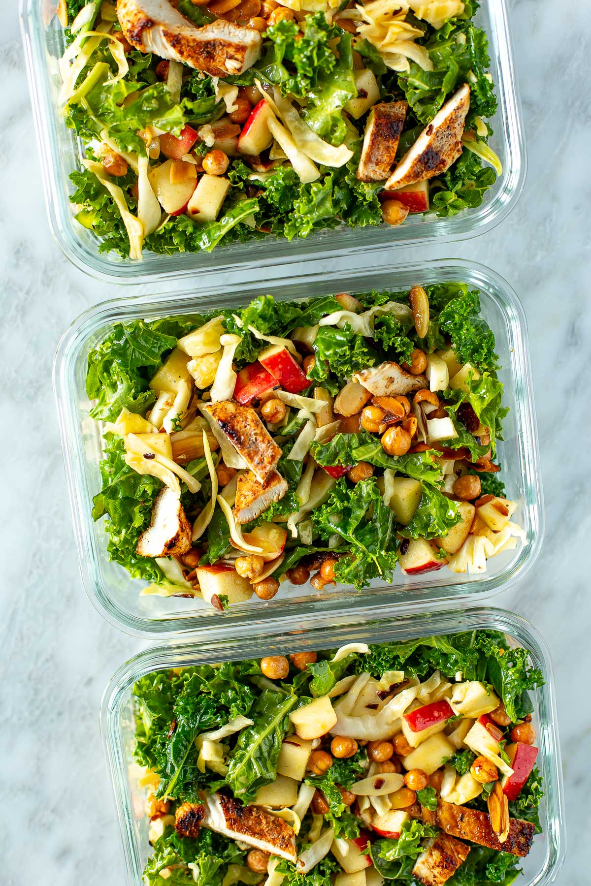 Overhead shot of three containers of kale crunch salad.