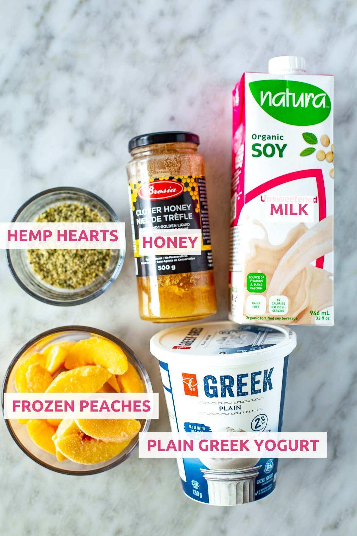 Overhead shot of high protein peach smoothie ingredients: hemp hearts, honey, soy milk, frozen peaches, and Greek yogurt.