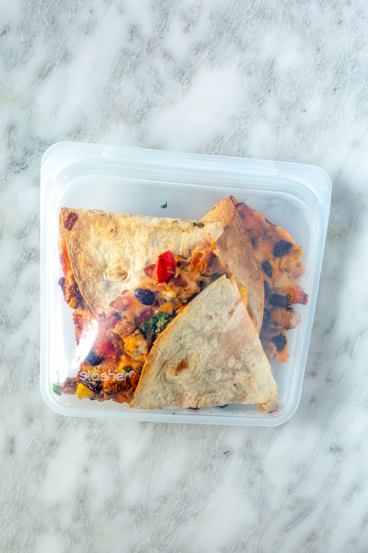 Overhead shot of cooked quesadilla slices inside a clear storage bag.