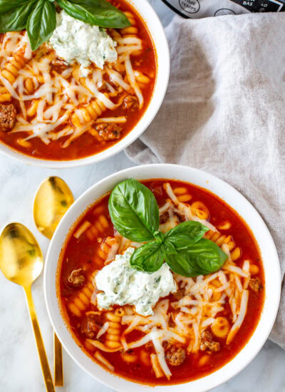 Overhead shot of two bowls of Easy Crockpot Lasagna Soup with gold spoons.