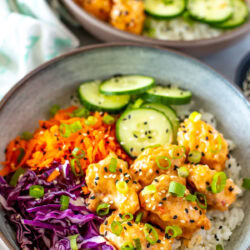 Side shot of two bowls of Bang Bang Chicken.