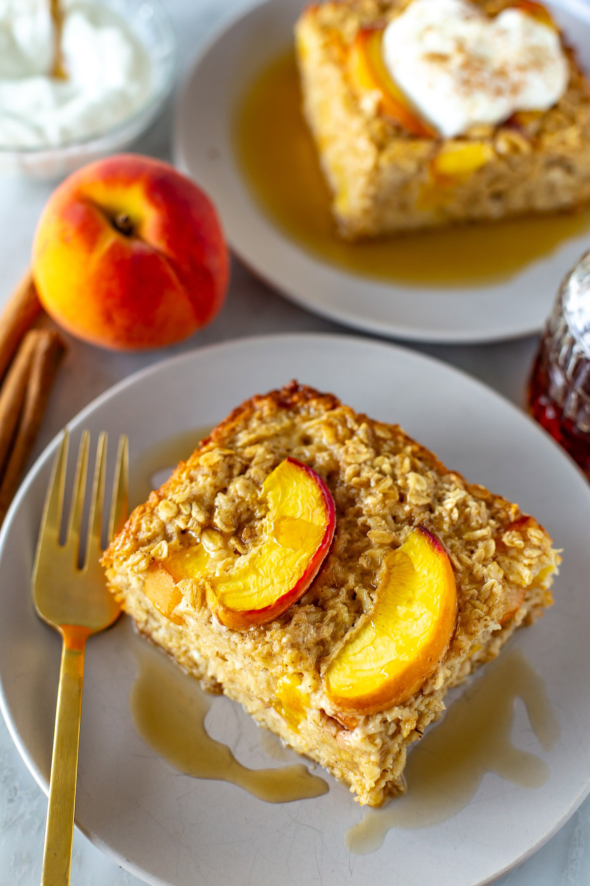 Side shot of a slice of baked peach oatmeal on a plate.