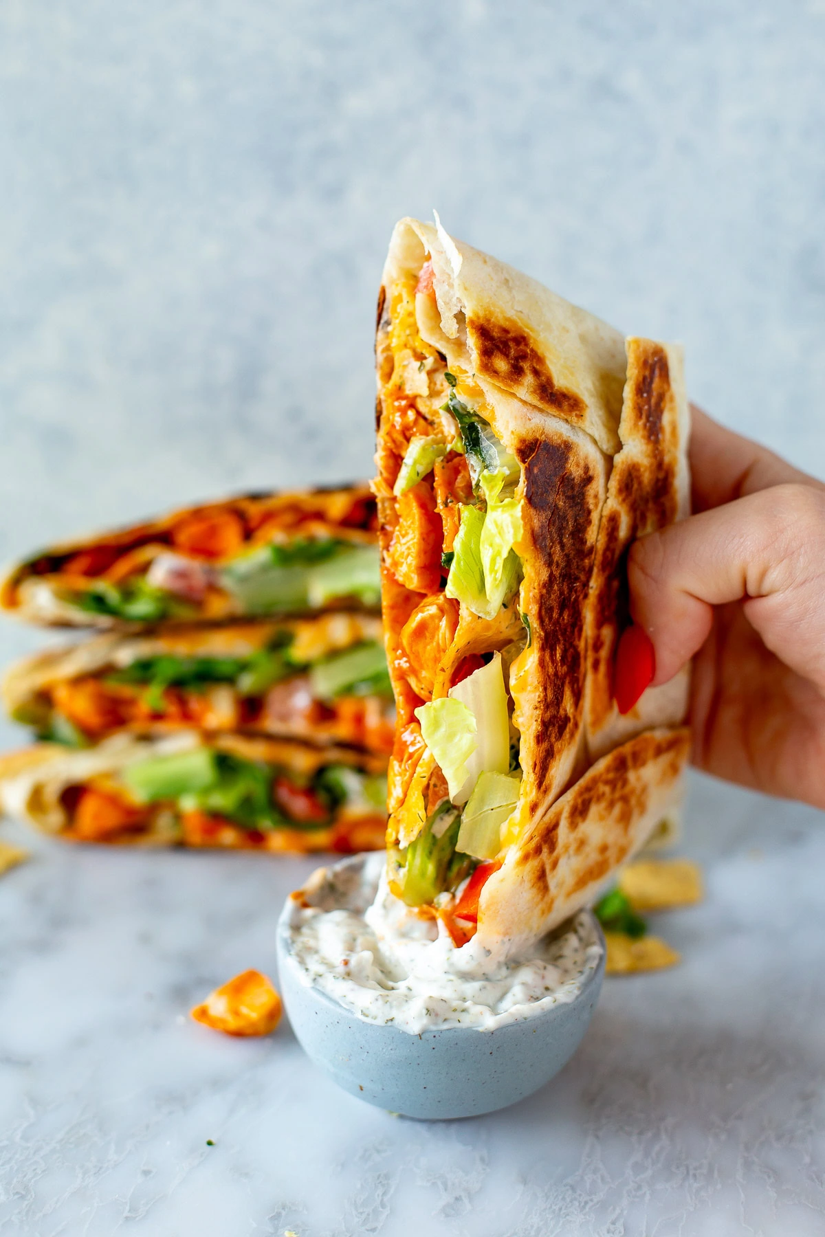 Buffalo chicken crunch wrap being dipped into ranch sauce