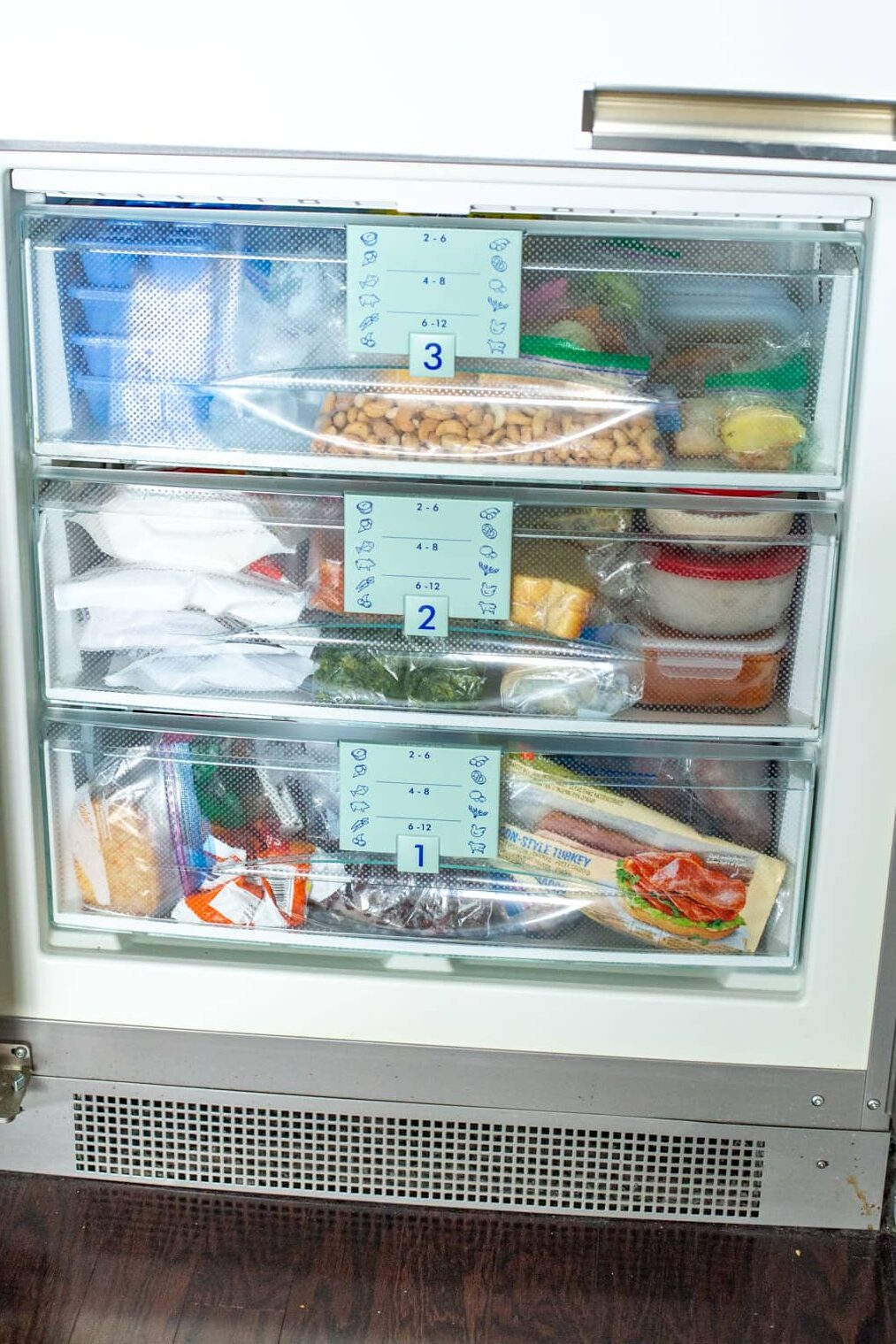 An organized freezer with 3 drawers.