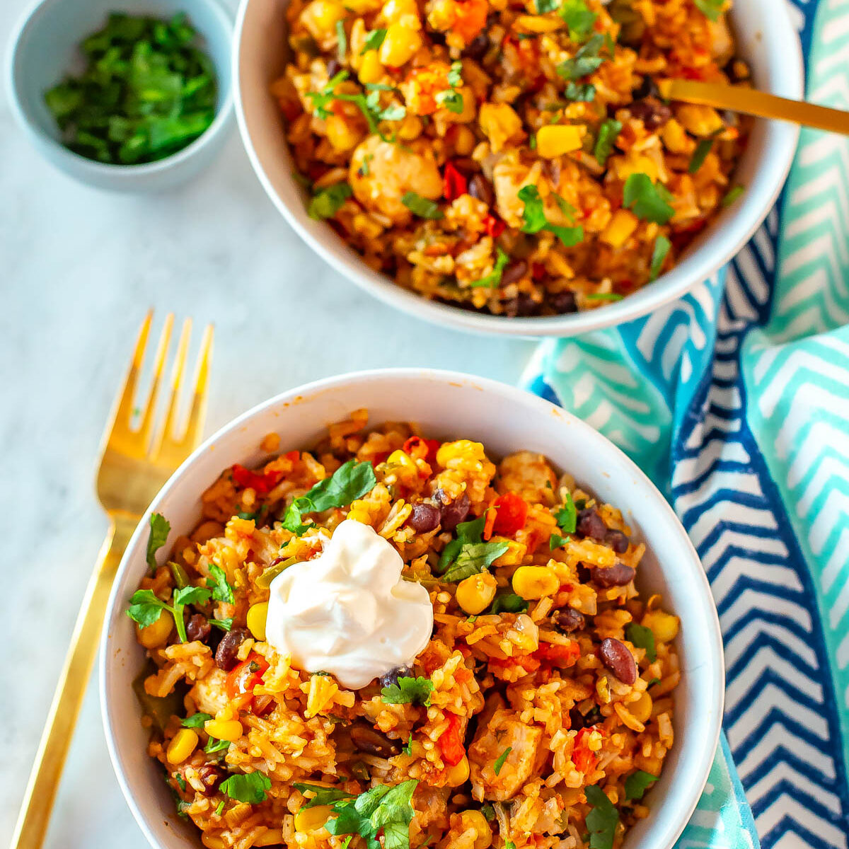 Two Instant Pot chicken burrito bowls topped with sour cream.