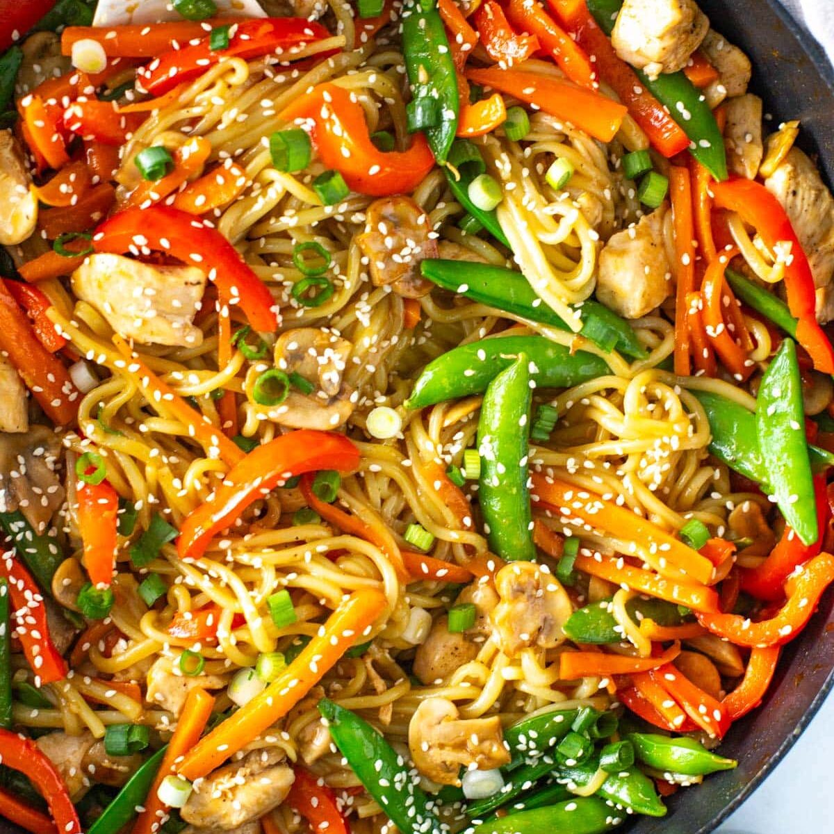 A close-up of chicken lo mein in a skillet.
